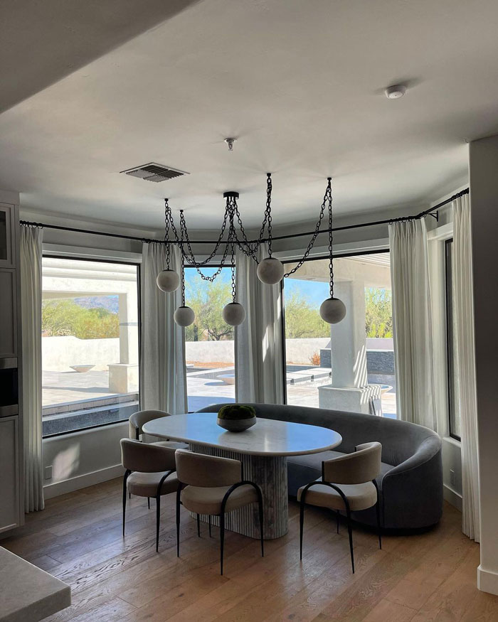 Breakfast nook next to the windows with a couch, chairs and interesting lamps on the ceiling Breakfast nook next to the windows with a couch, chairs and interesting lamps on the ceiling
