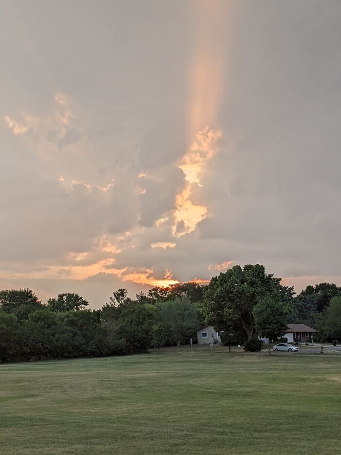 The Suns Rays Peeking Through The Clouds During Sunset