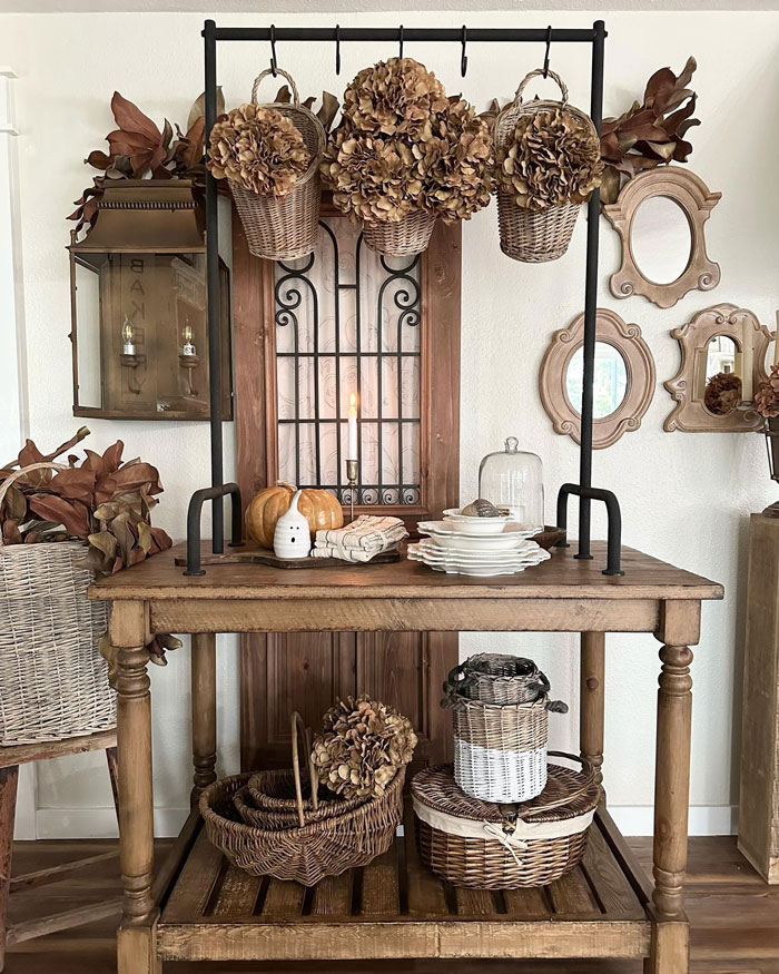 Farmhouse wooden table with baskets plates and flower decor