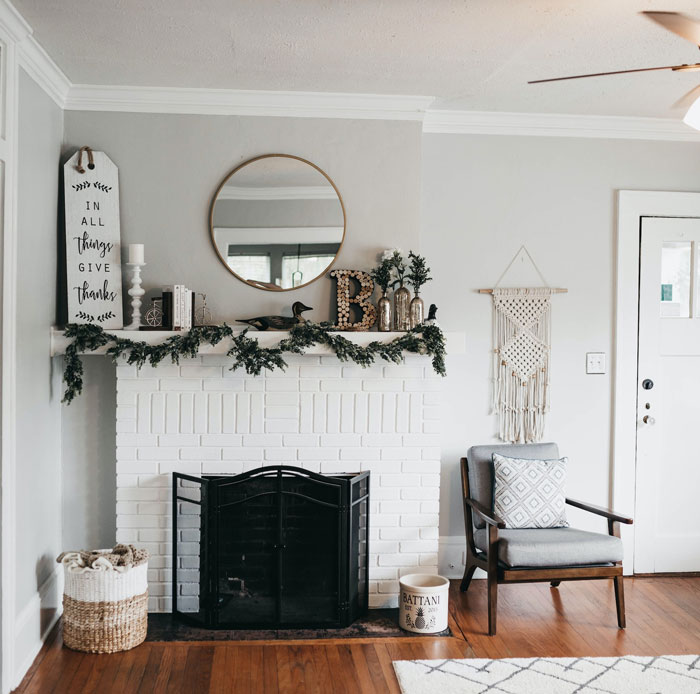 white fireplace mantel with decors and wooden floor