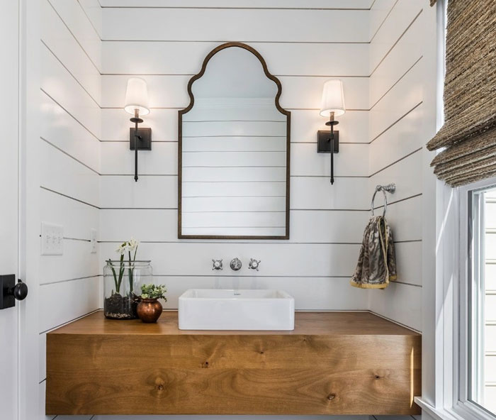 Bathroom with wooden table and sink and irregular mirror Bathroom with wooden table and sink and irregular mirror
