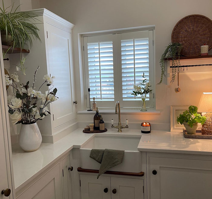 White cupboards with white sink and flowers
