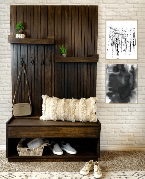 A wooden hall tree with accessories, shoe storage, and shelves against a white background