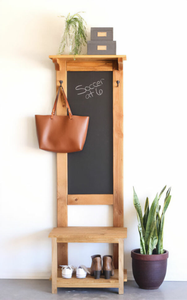 A wooden hall tree with a blackboard and a bag hanging from it