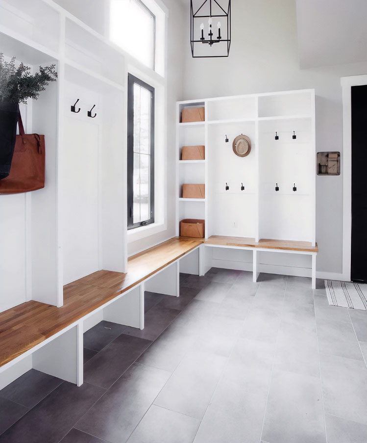 A white-washed wooden hall tree with a bench in the corner of a room A white-washed wooden hall tree with a bench in the corner of a room