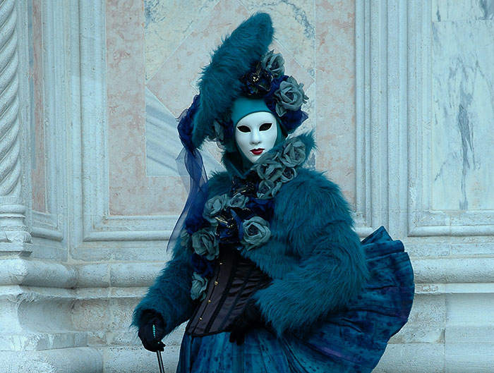 Woman wearing blue costume with white mask
