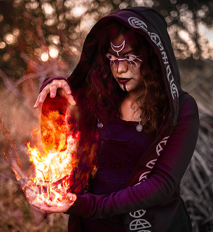 Woman wearing witch costume and making magic