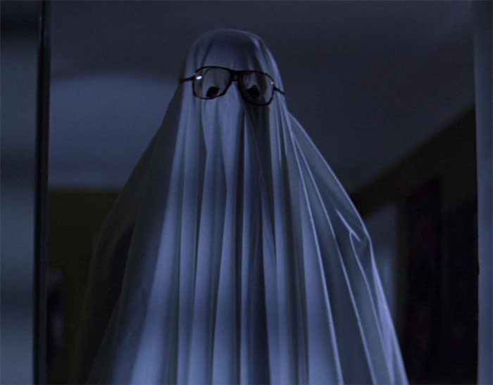 Man wearing ghost costume from movie Halloween