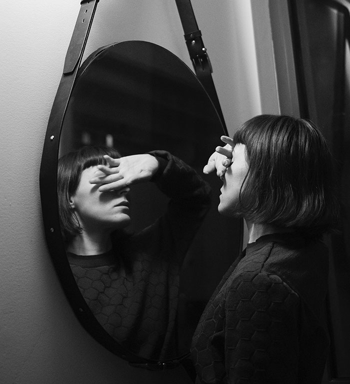 Black and white picture of woman looking at mirror