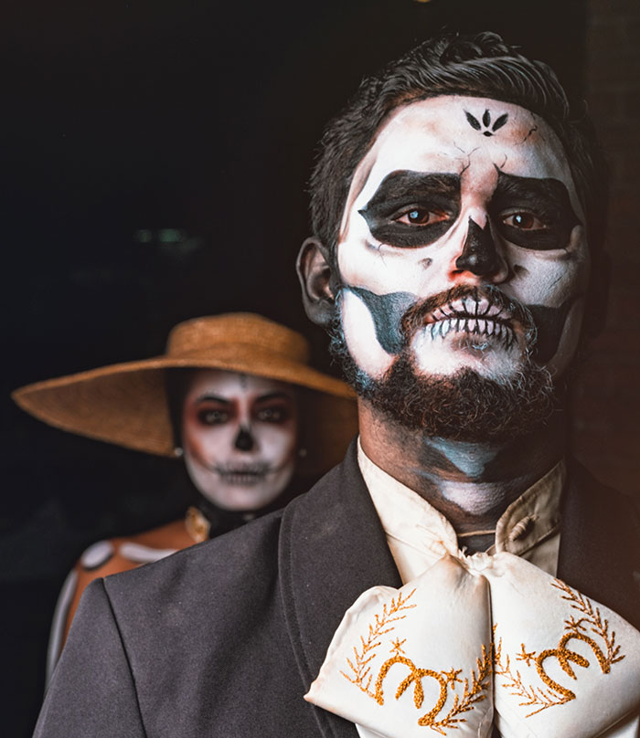Man and woman wearing skull costumes