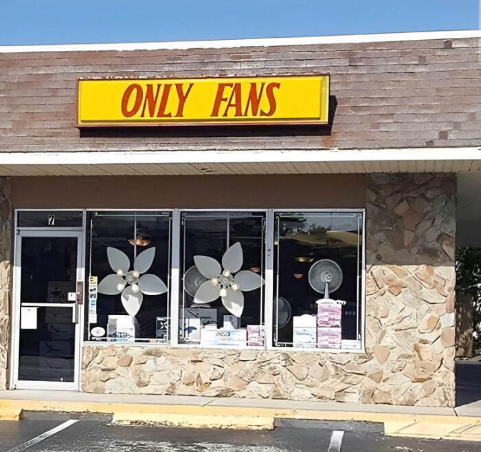Storefront with large fans in windows and a yellow sign reading ONLY FANS, a unique image for those venturing beyond internet.