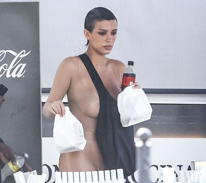 Bianca Censori in a daring outfit, holding a drink and fast food bag. Bianca Censori in a daring outfit, holding a drink and fast food bag.
