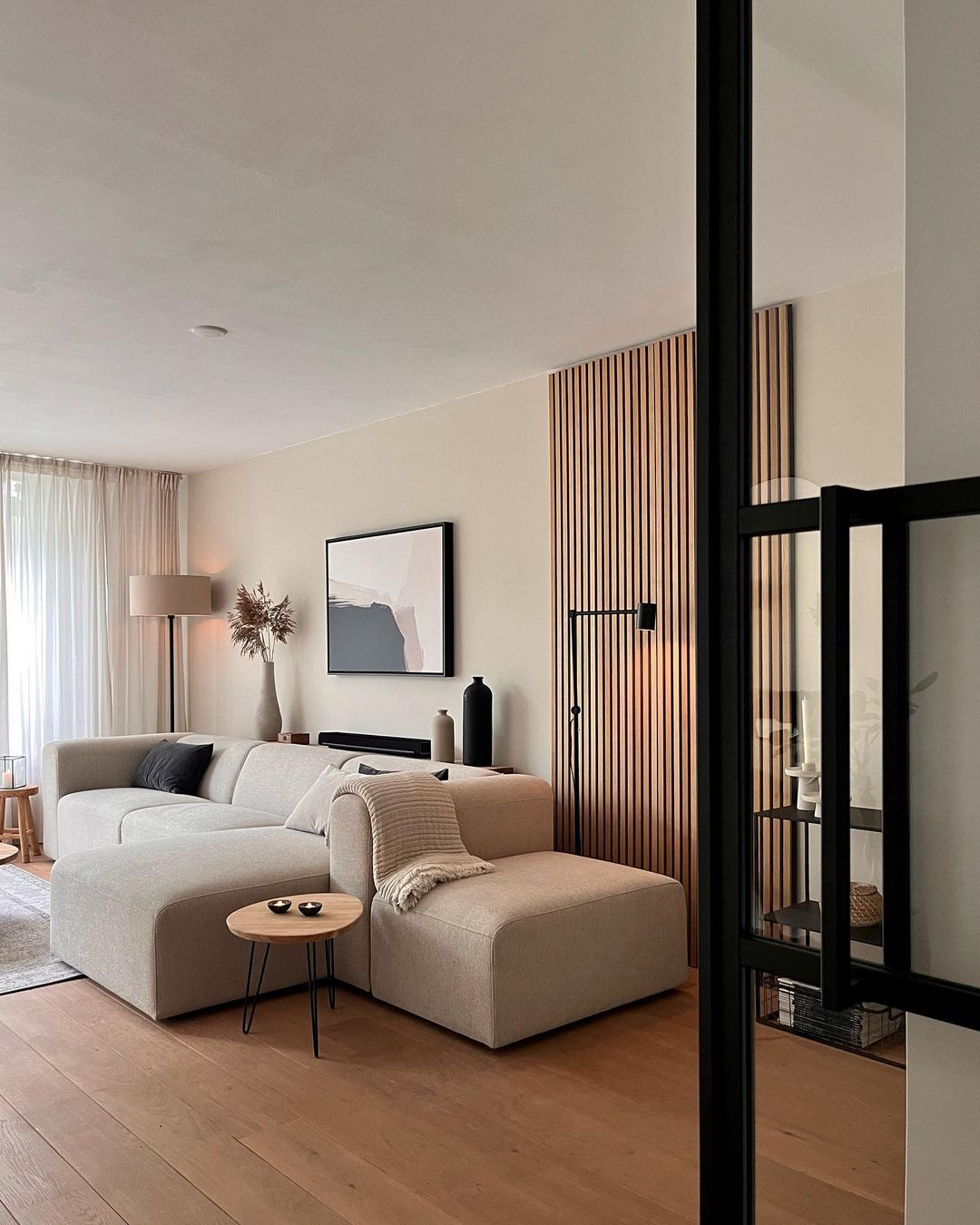 Modern beige living room featuring a large couch, wooden accents, and minimalist living room ideas for interior refresh. Modern beige living room featuring a large couch, wooden accents, and minimalist living room ideas for interior refresh.