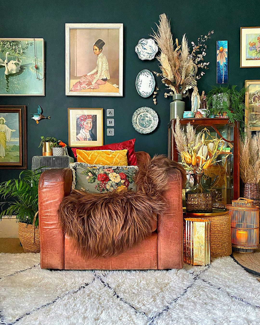 Colorful living space with leather armchair and loads of decorations and paintings on the walls