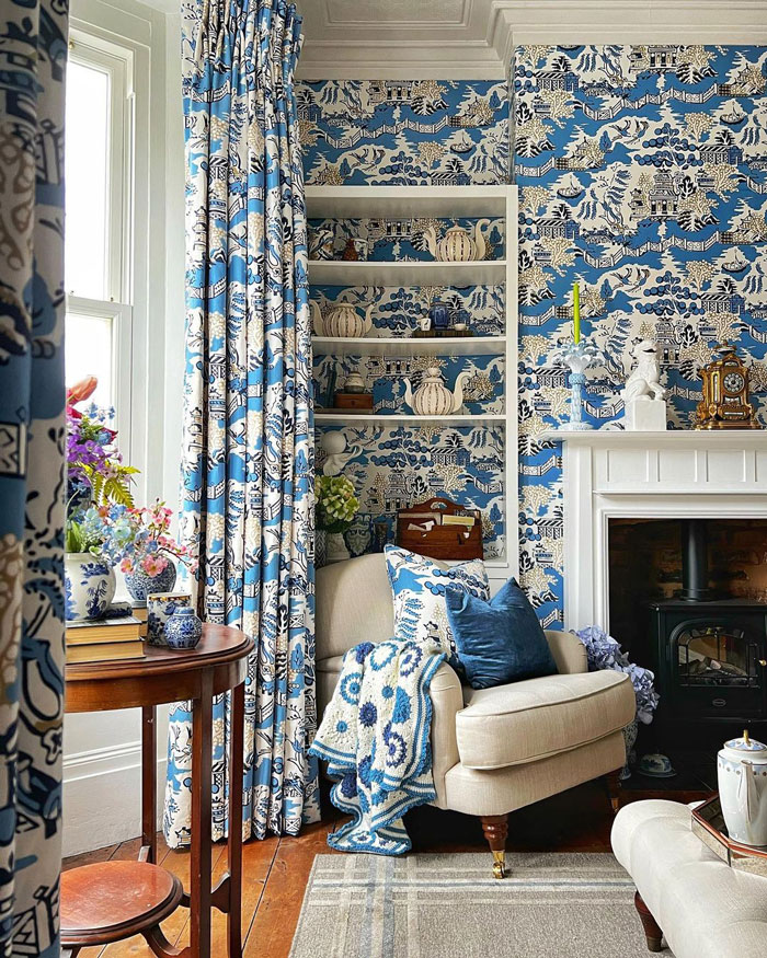 Living space with blue pattern wallpapers and curtains