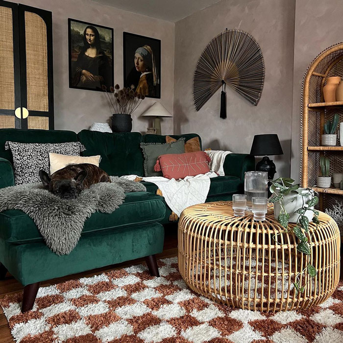 Living space with a green velvet couch and round wooden coffee table