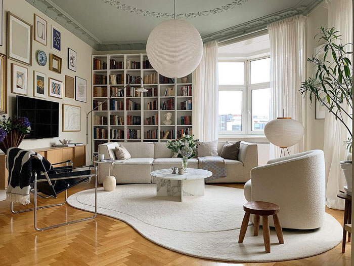 Living space with light green colored ceiling, white couch and book shelves across the entire wall