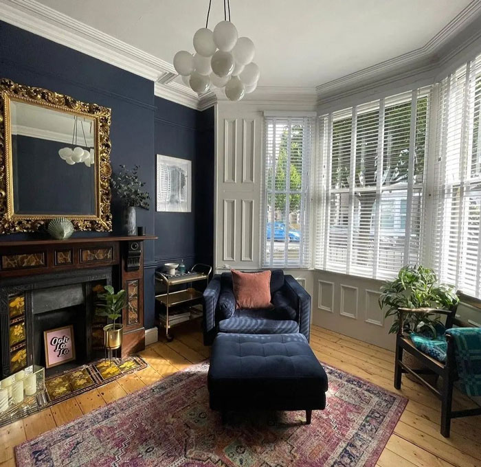 Elegant living room with armchair, fireplace, vintage mirror, and natural light showcasing living room ideas and designer insights. Elegant living room with armchair, fireplace, vintage mirror, and natural light showcasing living room ideas and designer insights.
