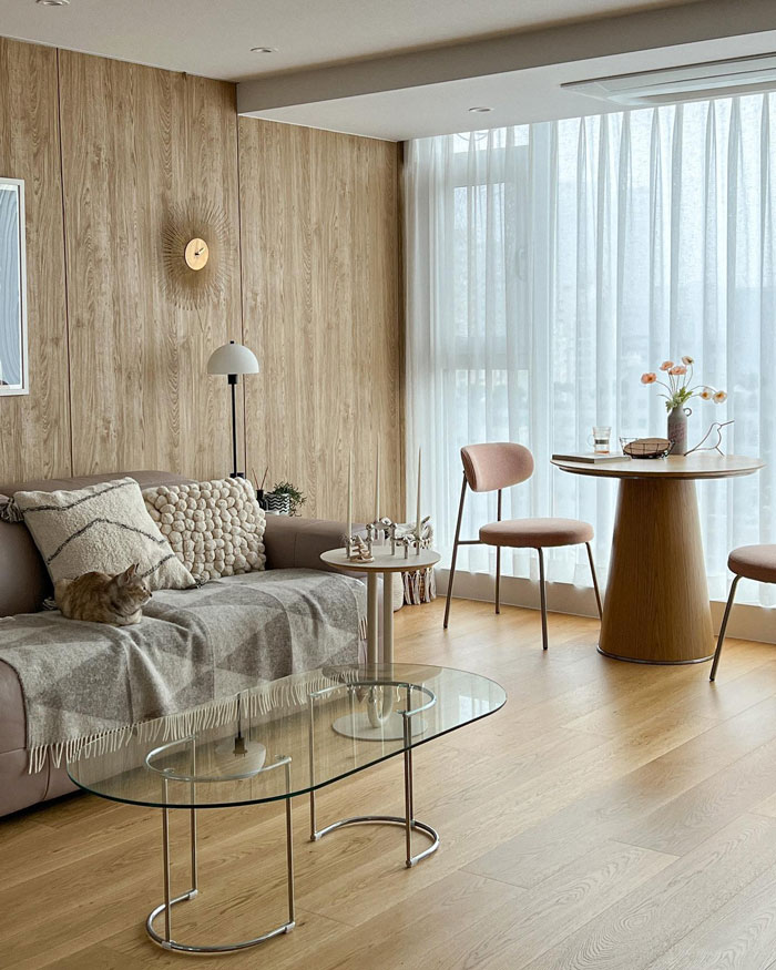 Beige living room with wooden walls, cozy couch, glass coffee table, and dining area showcasing living room ideas and design insights. Beige living room with wooden walls, cozy couch, glass coffee table, and dining area showcasing living room ideas and design insights.