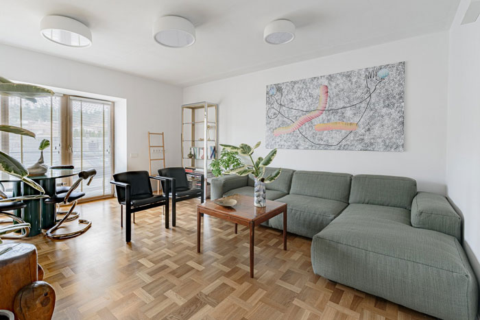 Living room with large gray L-shaped couch and modern painting, showcasing living room ideas and designer insights. Living room with large gray L-shaped couch and modern painting, showcasing living room ideas and designer insights.