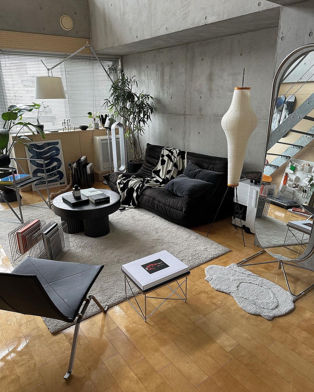 Industrial maximalist style living room with black futon couch