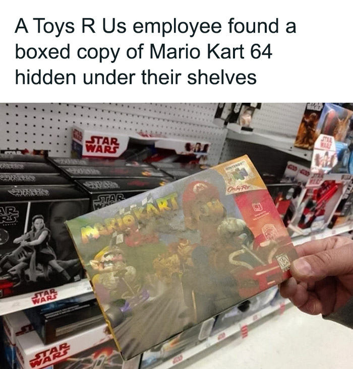 Toys R Us employee holds a dusted boxed copy of Mario Kart 64 game