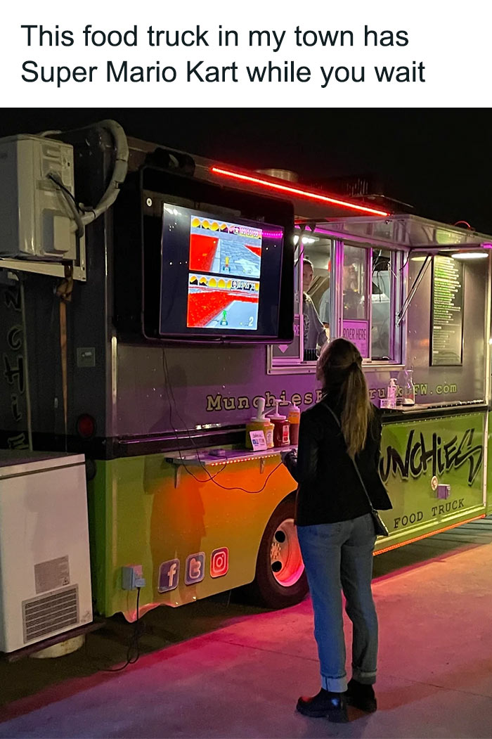 A woman standing near food truck and playing Mario Kart while waiting for food