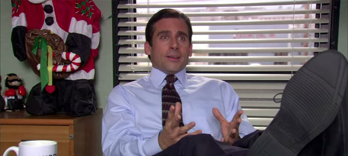 Michael Scott talking with his feet on the table