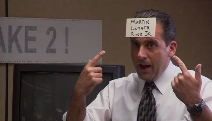 Michael Scott talking with a note on his forehead