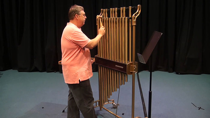 Man playing with Tubular bells instrument