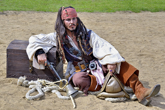 Fake Captain Jack Sparrow sitting near the chest
