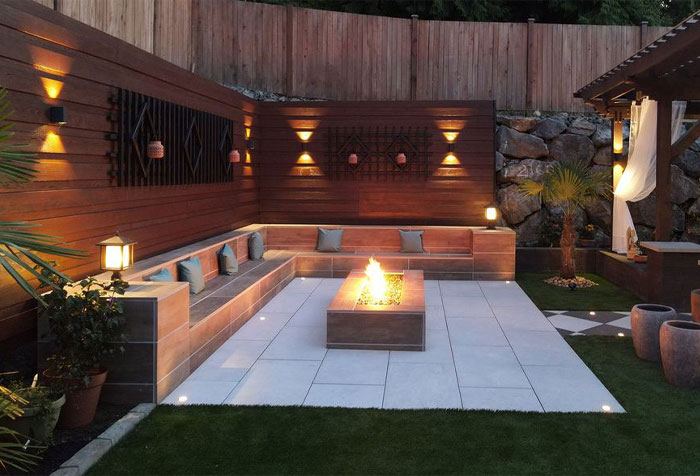 Backyard with fireplace and walls with sensor lights