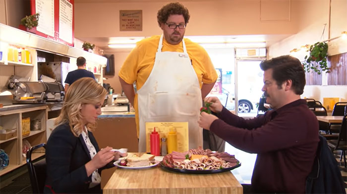 Ron Swanson taking out salads from meat plate in front of the waiter