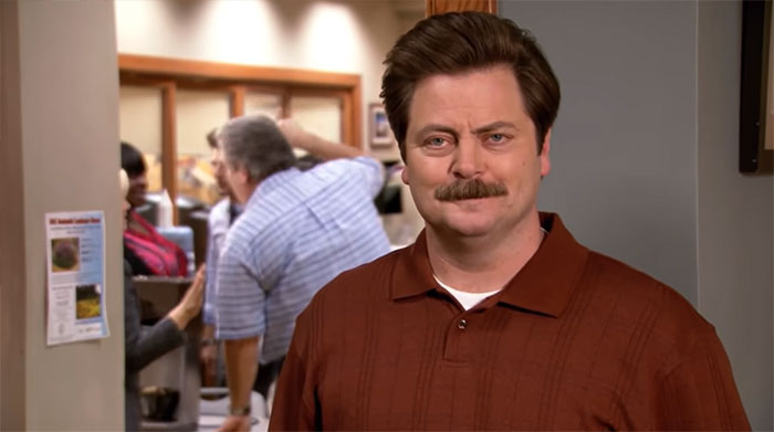 Ron Swanson smiling in front of the camera