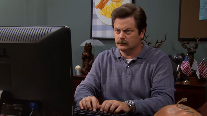 Ron Swanson is typing on a computer