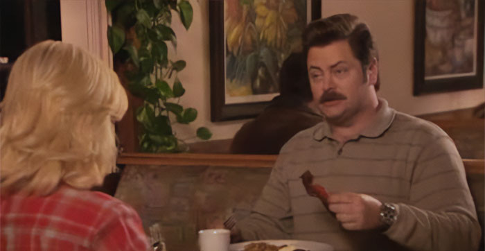Ron Swanson talking and eating a bacon