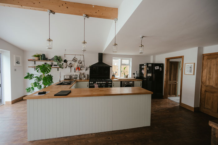 a large kitchen with a white L-shaped kitchen island