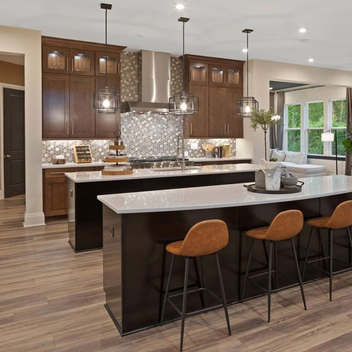 two kitchen islands and three bar chairs under a second kitchen island