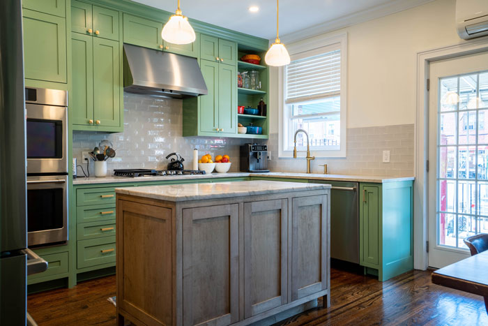 a kitchen with green cabinets and a kitchen island in the center