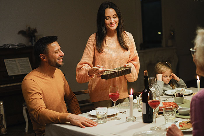 Family dinner scene with a woman serving food, highlighting tension around woman giving her baby to her sister. Family dinner scene with a woman serving food, highlighting tension around woman giving her baby to her sister.