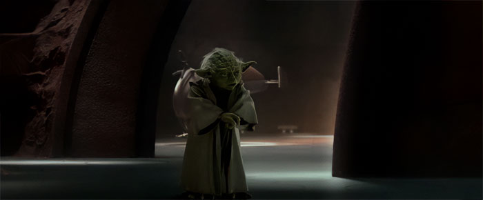 Yoda standing with a walking stick and talking