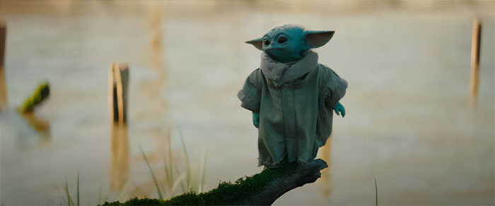 Baby Yoda standing on a bench