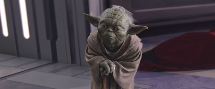 Yoda standing with a walking stick