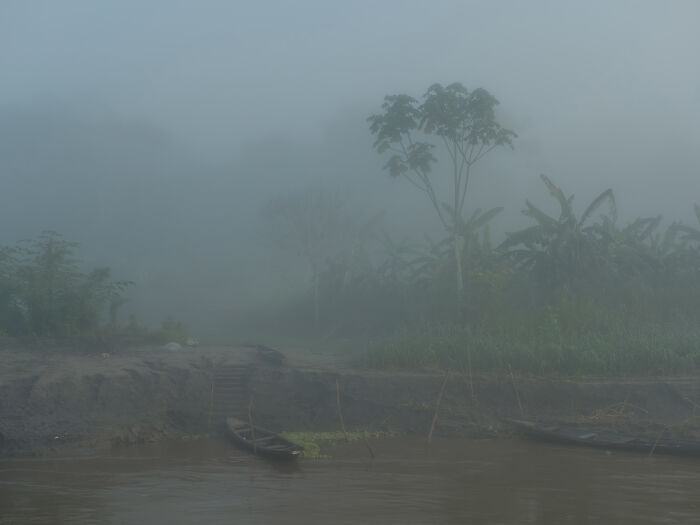 Early morning mist and wooden boats on the shore of the Amazon River