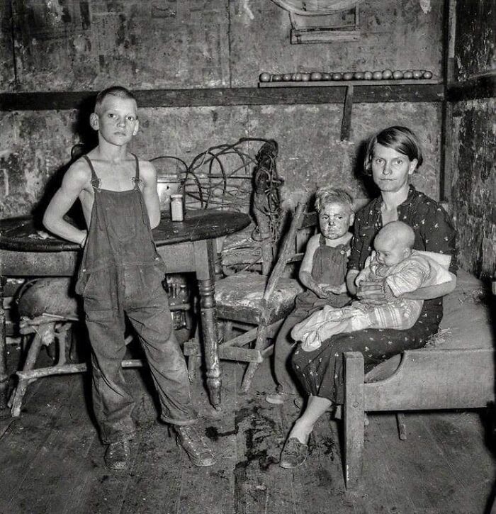 Esposa de un minero y 3 de sus hijos en la casa proporcionada por la compañía minera, Pursglove, Scotts Run, Virginia Oriental, Septiembre de 1938