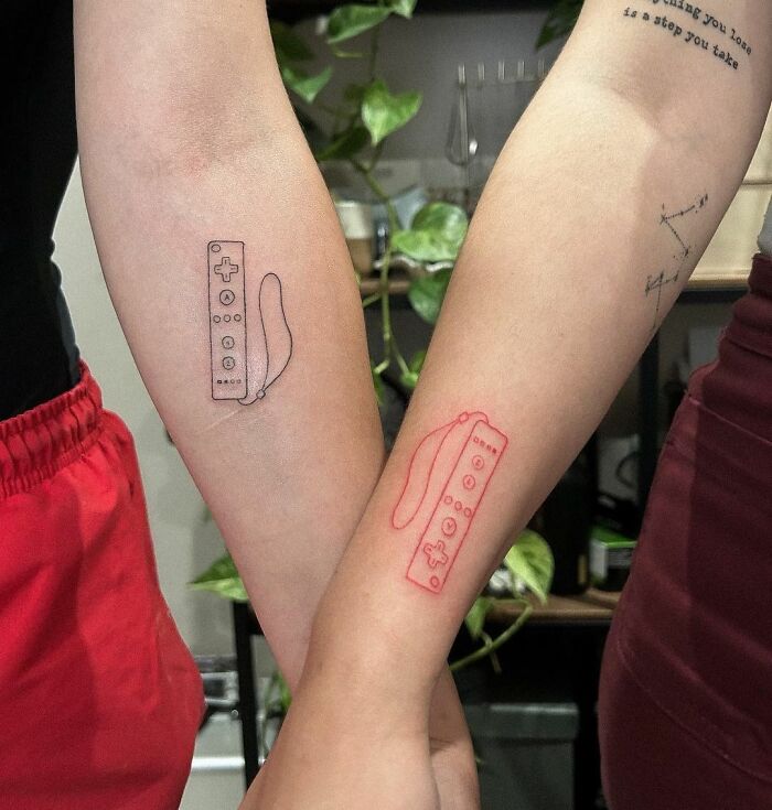 Matching black and red game consoles arm tattoos 