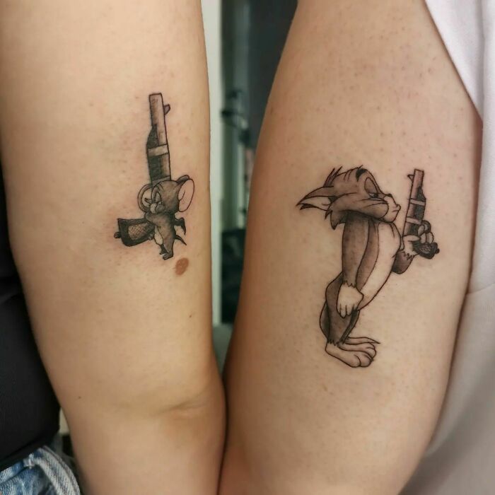 Tom and Jerry with weapons tricep tattoos