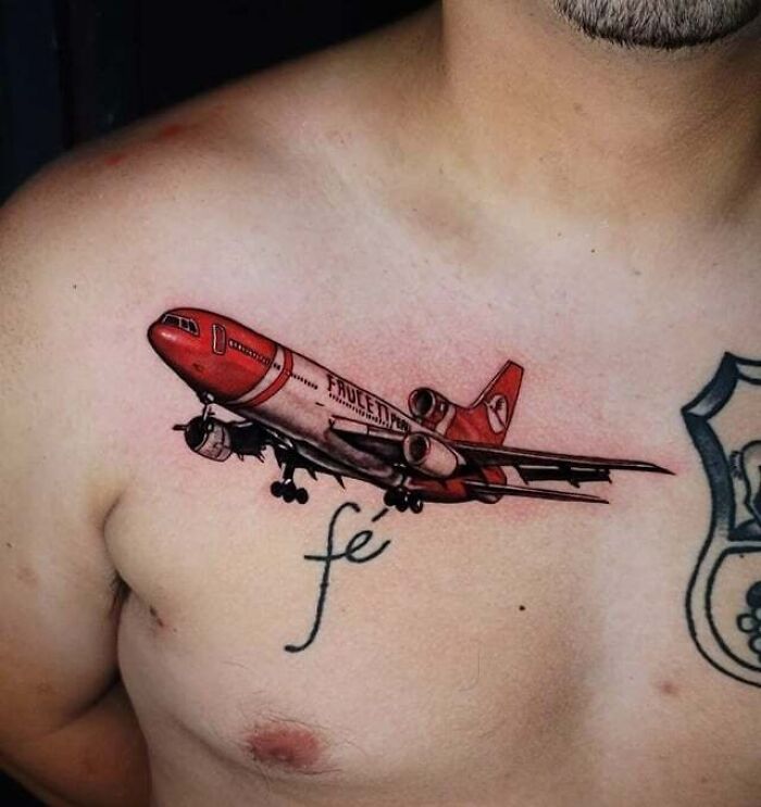 Colorful red plane chest tattoo