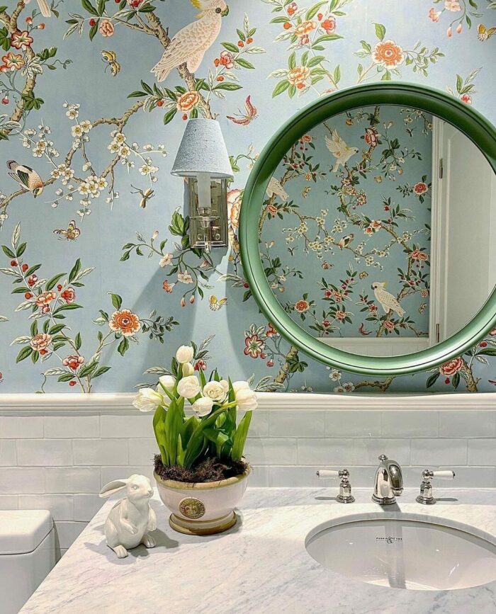 Bathroom with marble sink and blue wallpaper decorated with branches and birds