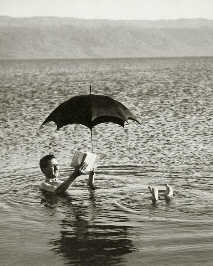 A Man Floating In The Dead Sea With A Book And An Umbrella. 1920